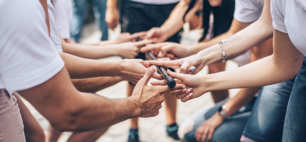 Teambuilding Exercises With Stick And Hands Of Colleagues