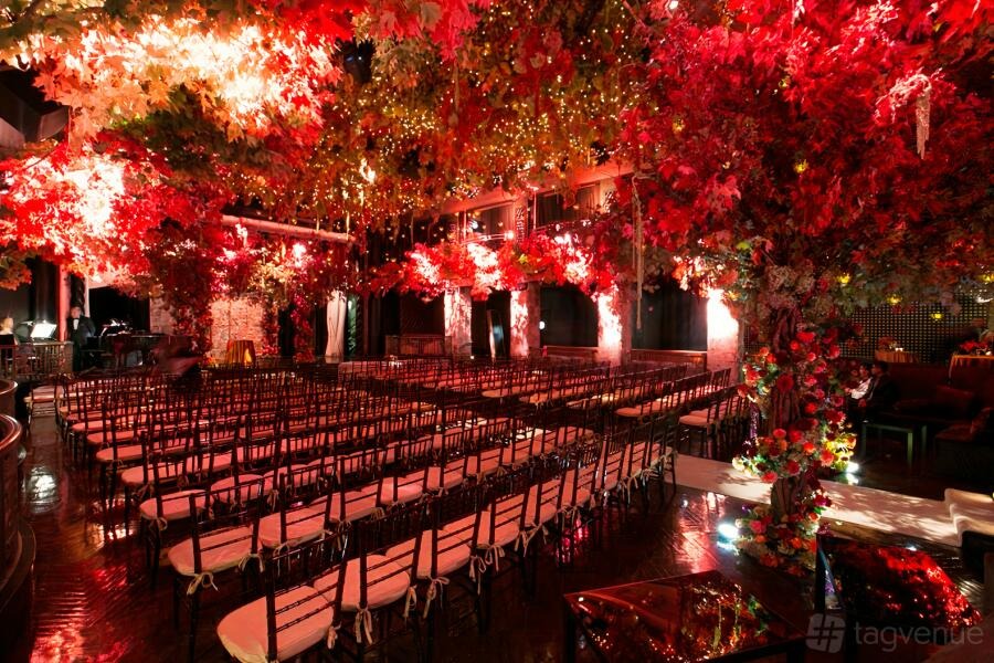 Black-Tie Christmas: red foliage canopy over rows of gold chairs in the Edison Ballroom, New York City