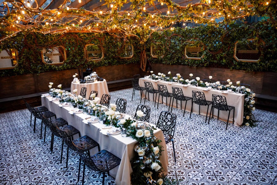 Enchanted Winter Garden: long white-linen table under a fairy-lit canopy of foliage at SAINT, New York City