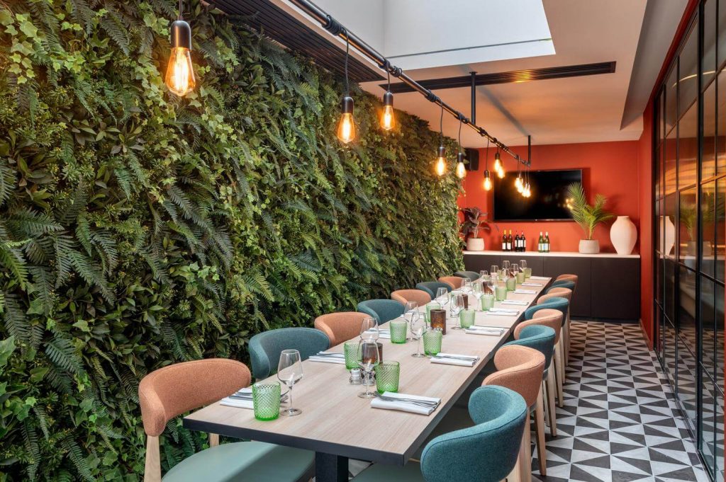 a venue with plant wall and pastel decor in london