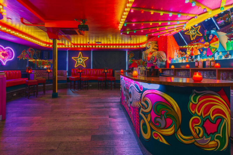 Fairground themed bar with colourful lights and decor