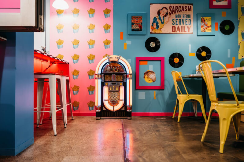 Colourful, 1950s style diner with a jukebox in the centre.