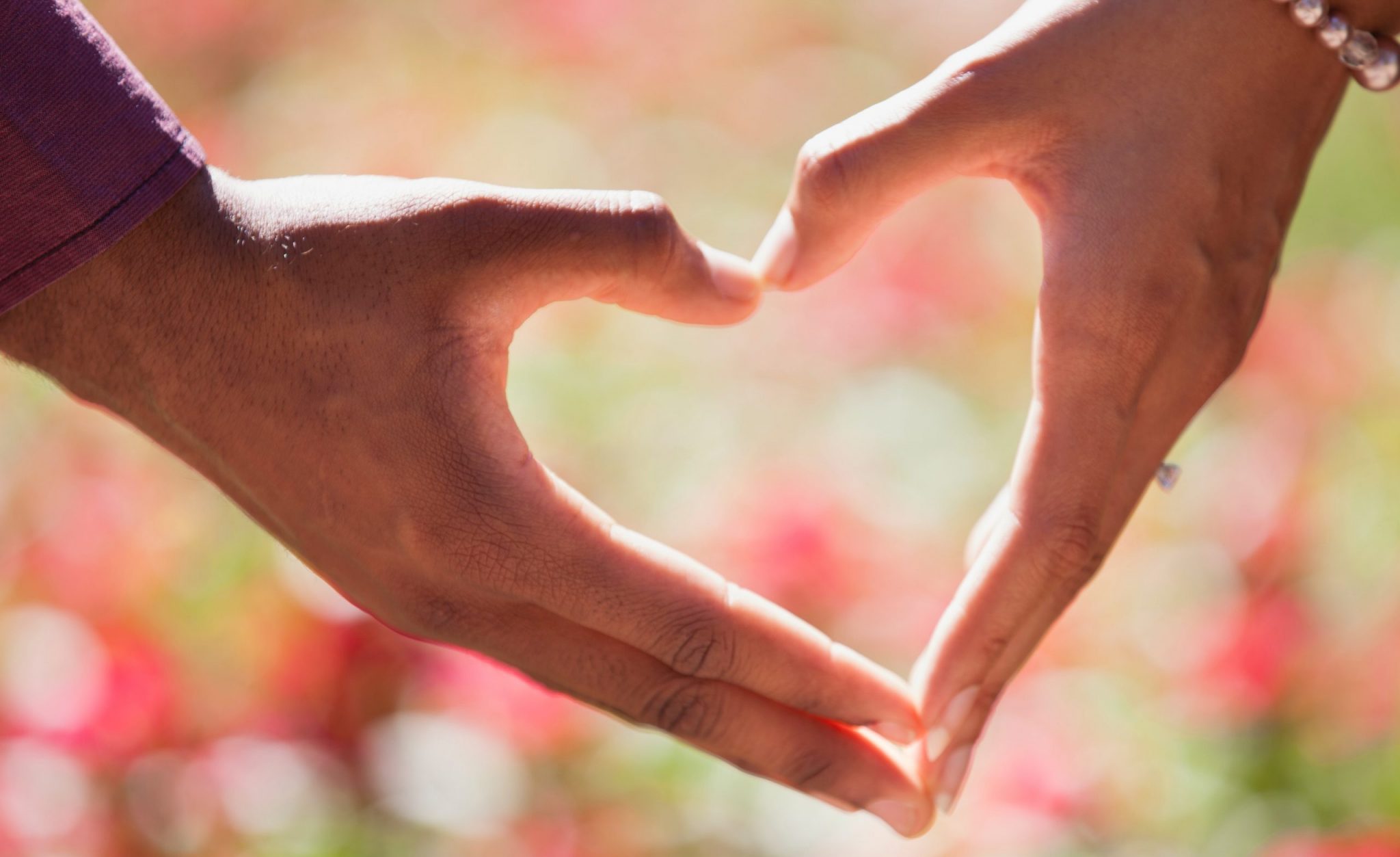 a couple making a heart with their hands