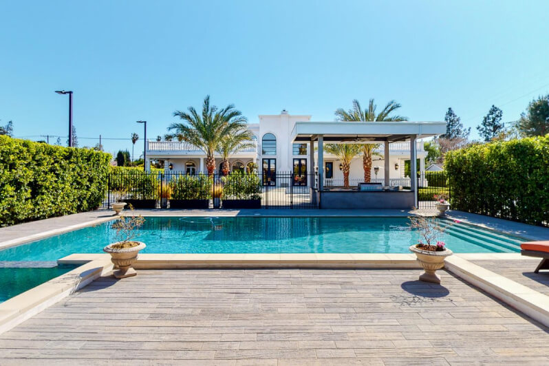Large pool in front of a villa in a sunny location.