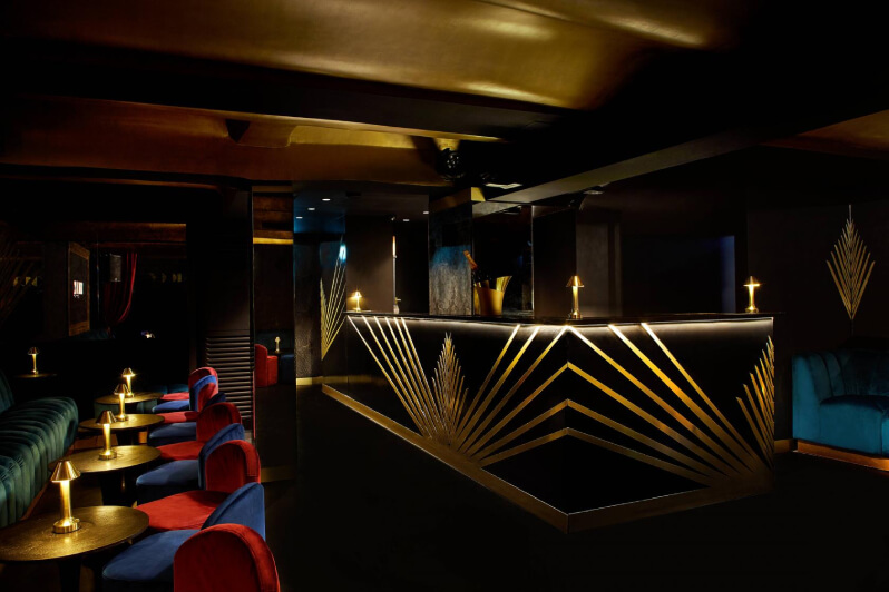 Elegant and stylish bar with gold decor, small tables, and a large bar counter for 30th birthday party