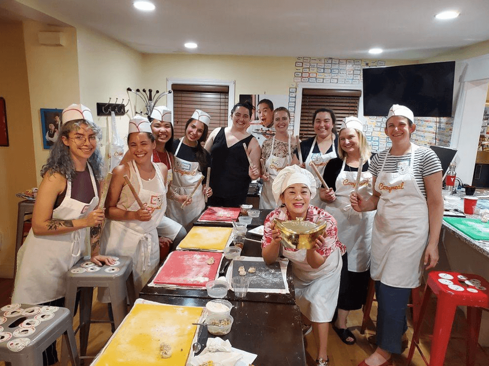 a group of smiling people during a cooking class
