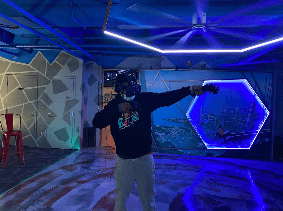 A guy dressed in a VR set in a blue-lit venue