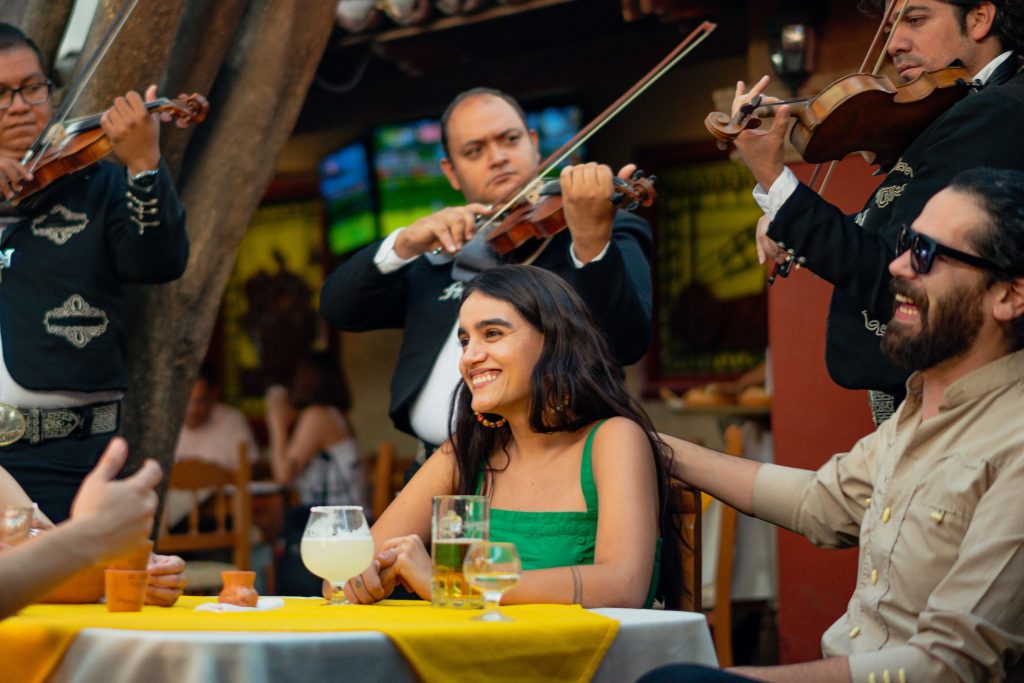 people at the table smiling while mariachi band plays behind them