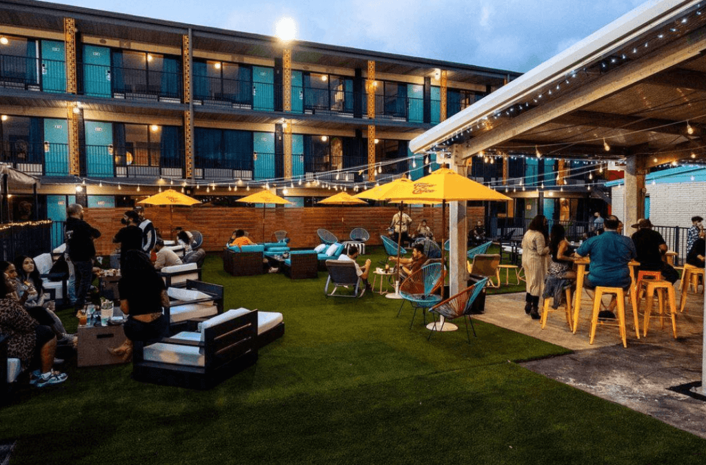 an outdoor rooftop venue venue surrounded by at dusk filled people enjoying a party