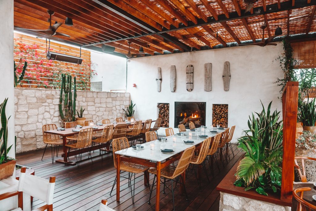 A garden patio restaurant setting with African decor elements, cactuses, and other green plants.