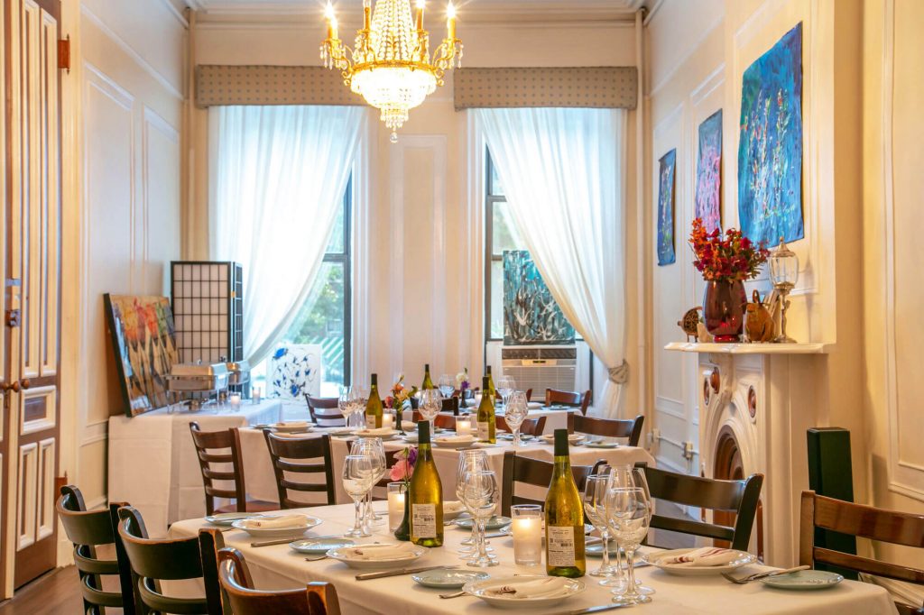 A French restaurant interior featuring tables with wine bottles and glasses.