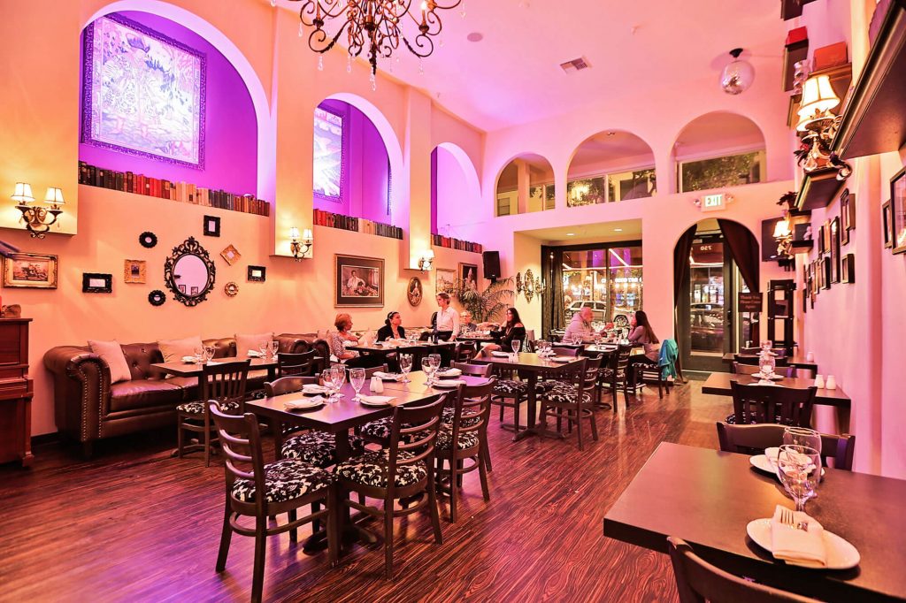 A pink-illuminated, chic restaurant interior.