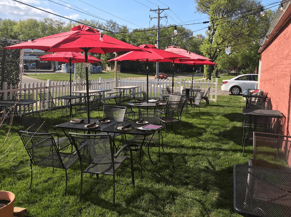 tables and chairs covered by umbrellas on a sunny patio