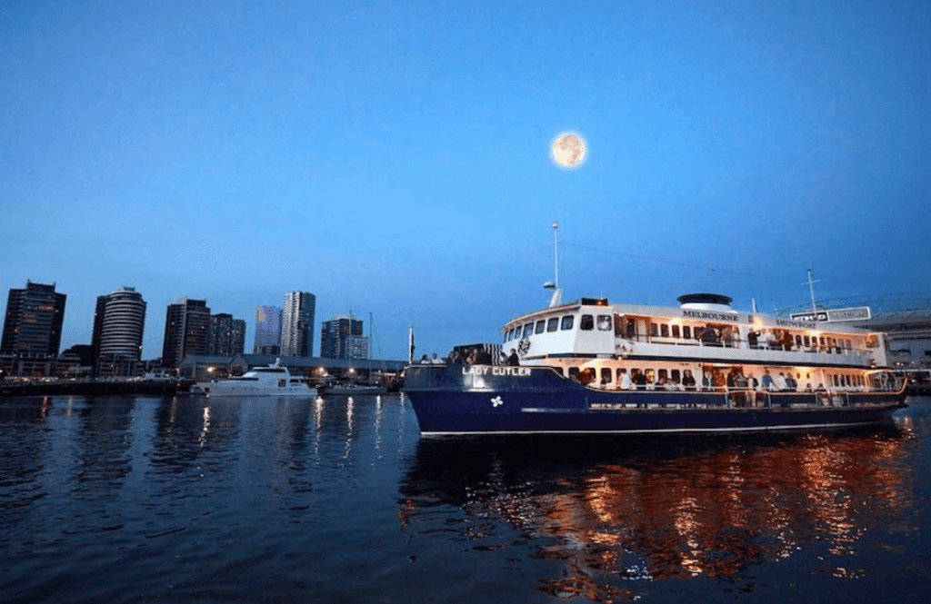 A view of a boat against a city during a night