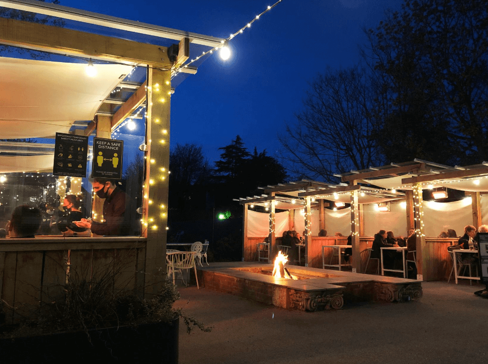 outdoor venue space with private booths and a central fire place