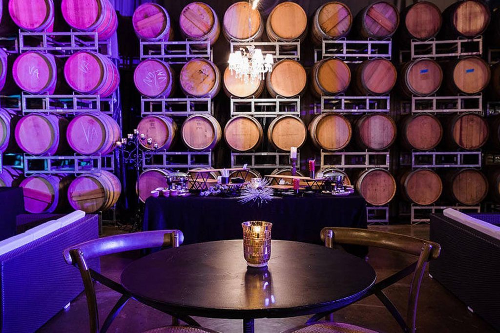 A table set against a wall with wine barrels