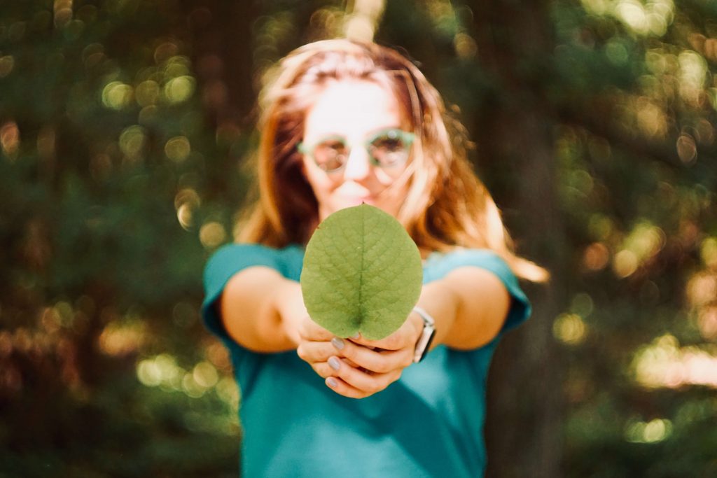Woman showing leaf to represent her love for nature