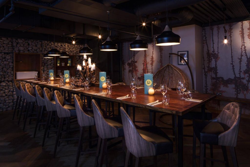 dimly lit room with a table set up for a dinner