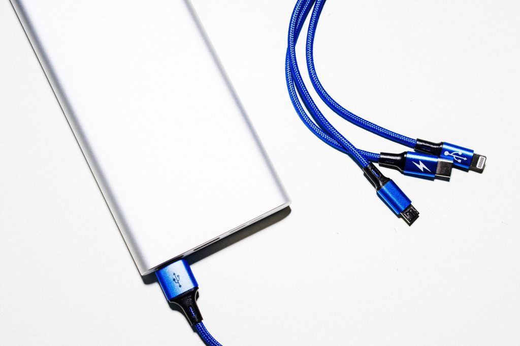 a white powerbank with blue cables 