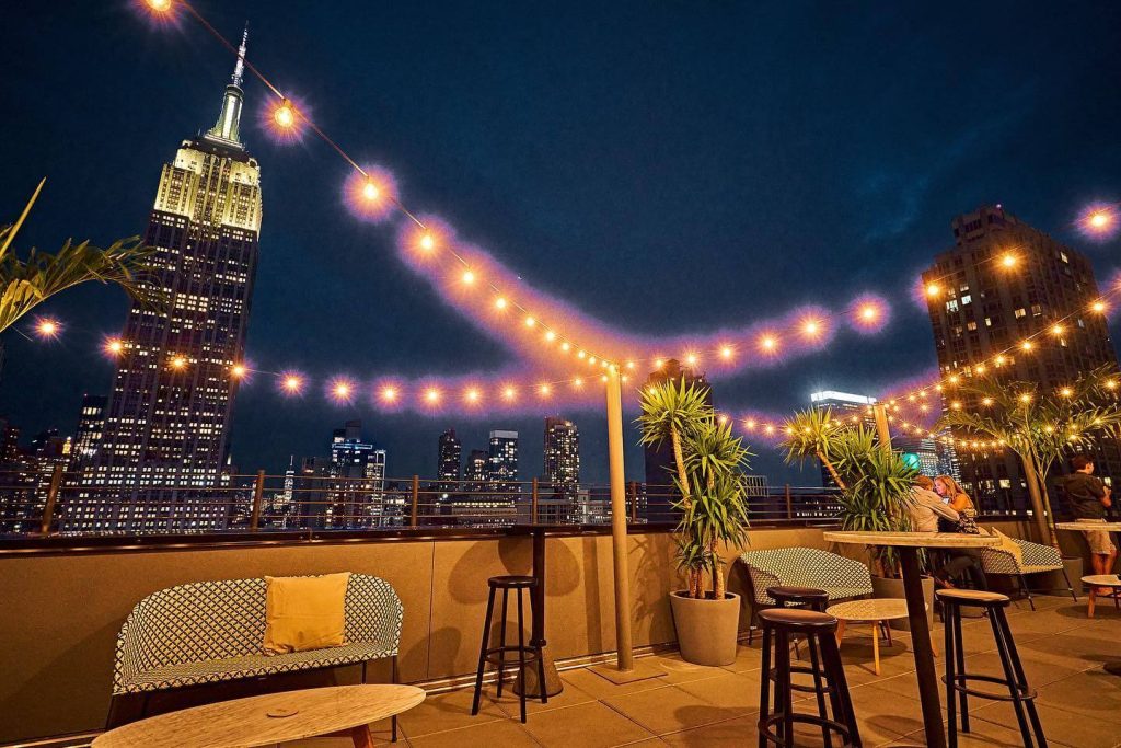 A rooftop venue with a view of night-time NYC