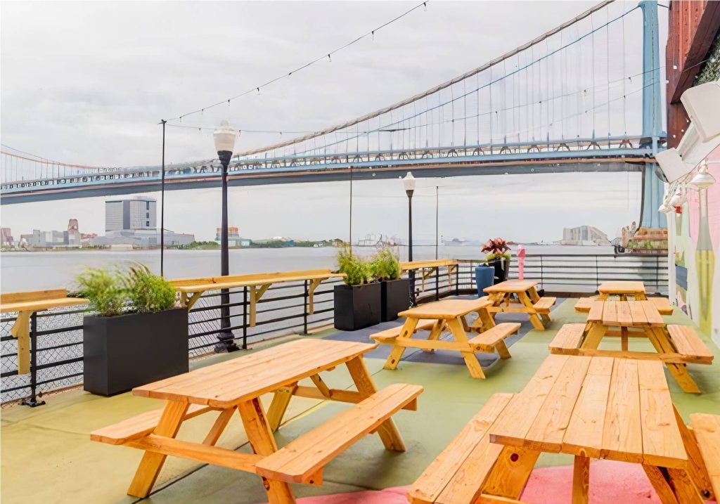 an outdoor area with tables and benches with views of Delaware River
