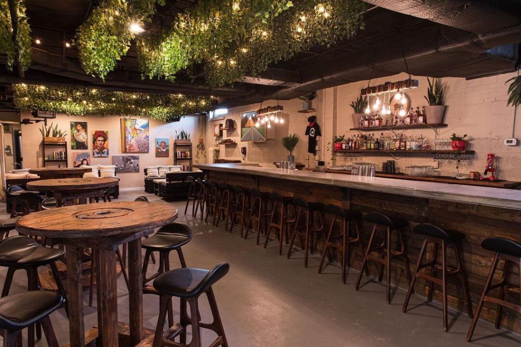 a bar decorated with wood and green plants