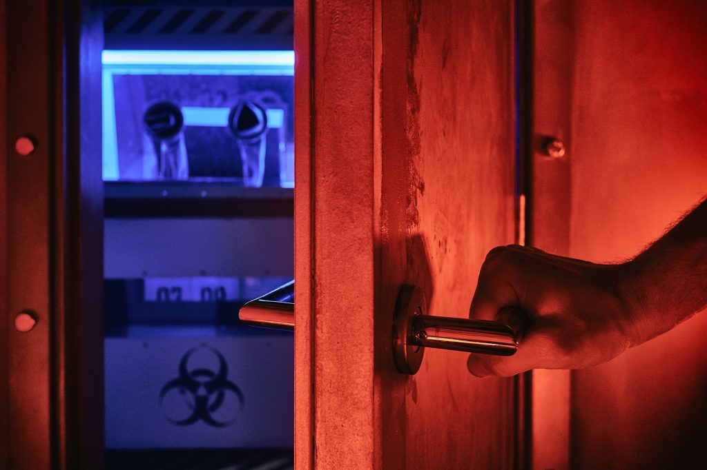 Mysterious escape room doorway bathed in ominous red light, suggesting an adventurous birthday activity with a biohazard sign for an added thrill.