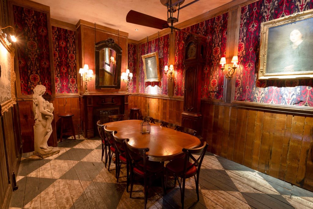 Quaint private dining room featuring traditional wood panelling, vintage portraits, and antique furniture for a classic British birthday dining experience.