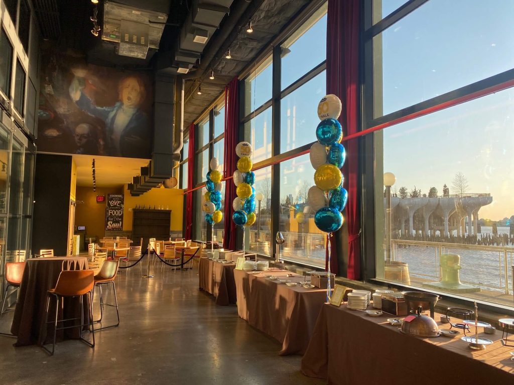 Bright and airy dining room with large windows offering Hudson River views, decorated for a birthday celebration.