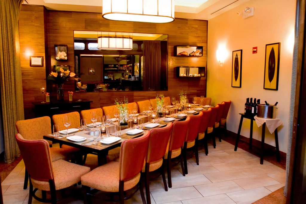 Elegant private dining space with a modern wine cellar, rich wooden accents, and stylish furniture for a celebratory dinner.