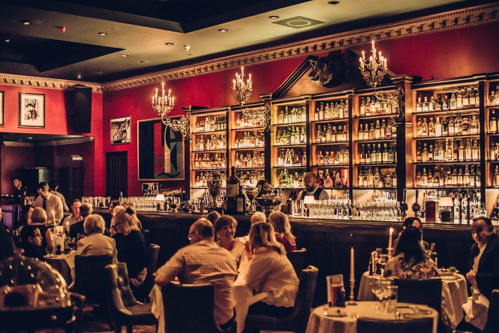 Intimate jazz night setting with patrons and a fully stocked bar at Boisdale of Canary Wharf, London, perfect for a stag do
