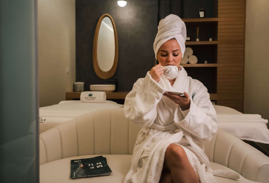 a woman drinking from a tea cup in a spa room