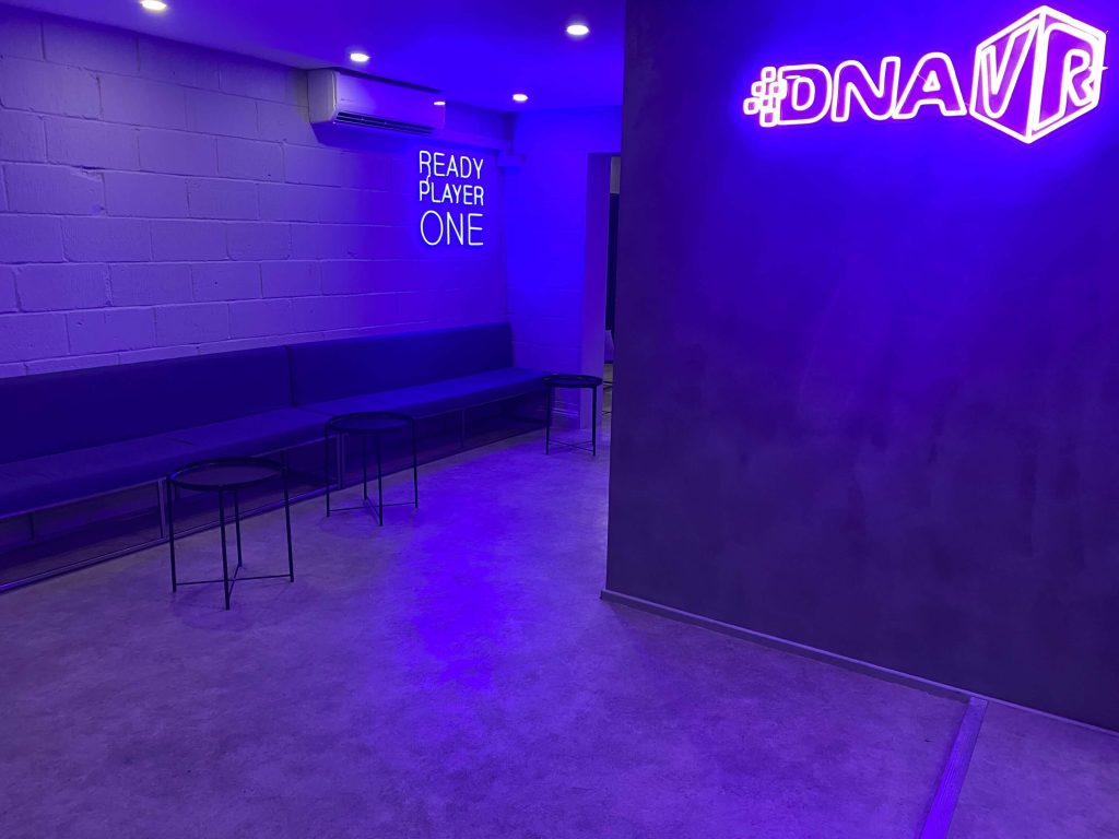 Minimalist waiting area with neon signage at DNA VR in Camden, London, a modern virtual reality experience for a stag party