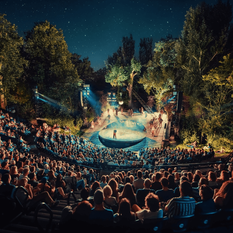 Open-air theatre in London filled with spectators, capturing the essence of cultural summer party ideas in the city.