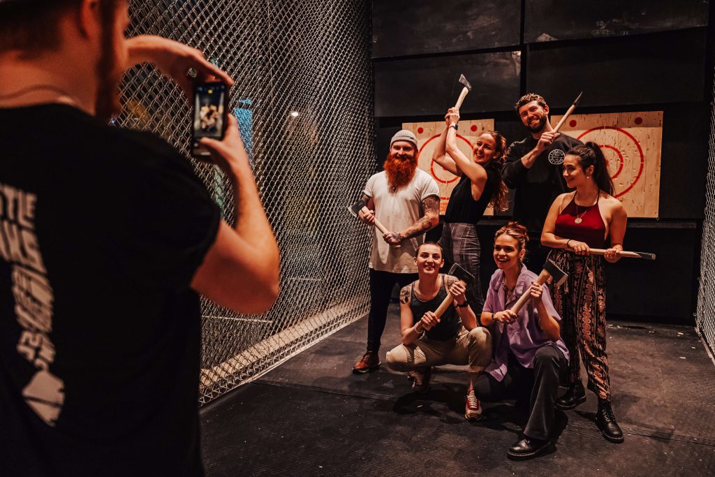 Group enjoying an axe-throwing birthday activity in London, a thrilling idea for his celebration.