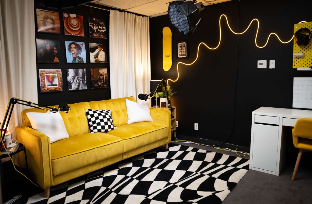 Lazy Pickle Studios Burbank is a quirky and colorful event space  with a yellow couch  and colourful frames of popular artists on the wall