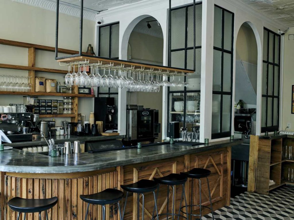 a rustic bar with a marble tabletop and leather bars.