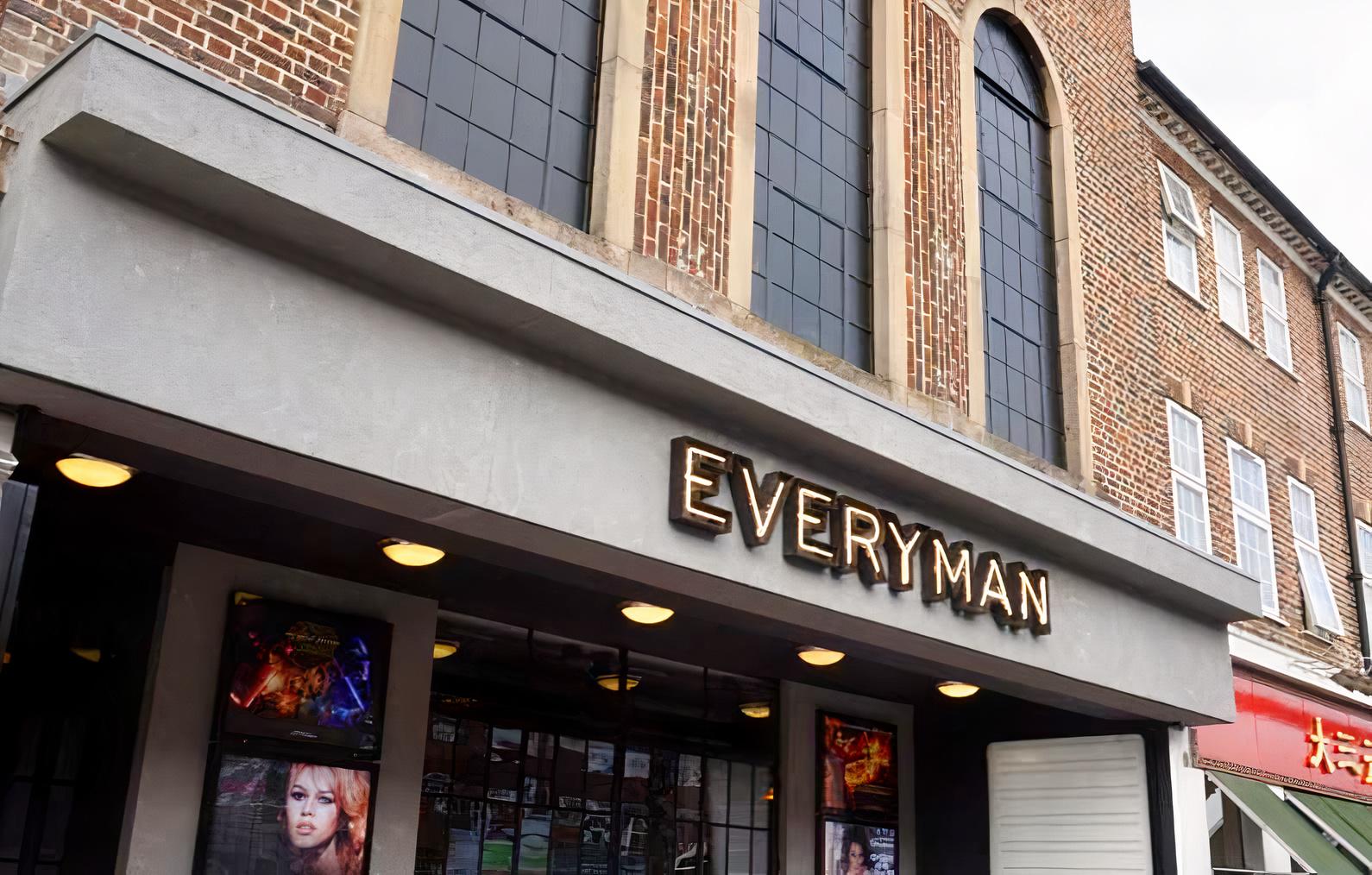 A cinema with large arched windows and a marquee sign above the entrance at Everyman Esher.