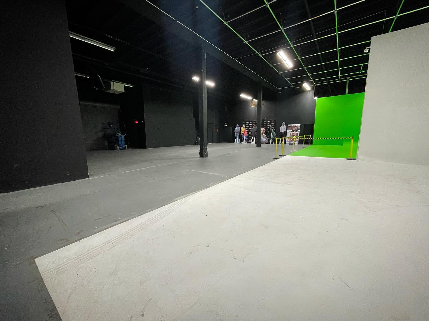 A photo studio with a large green cyclorama wall, open floor space, and high ceilings at Mann Robinson Studio.