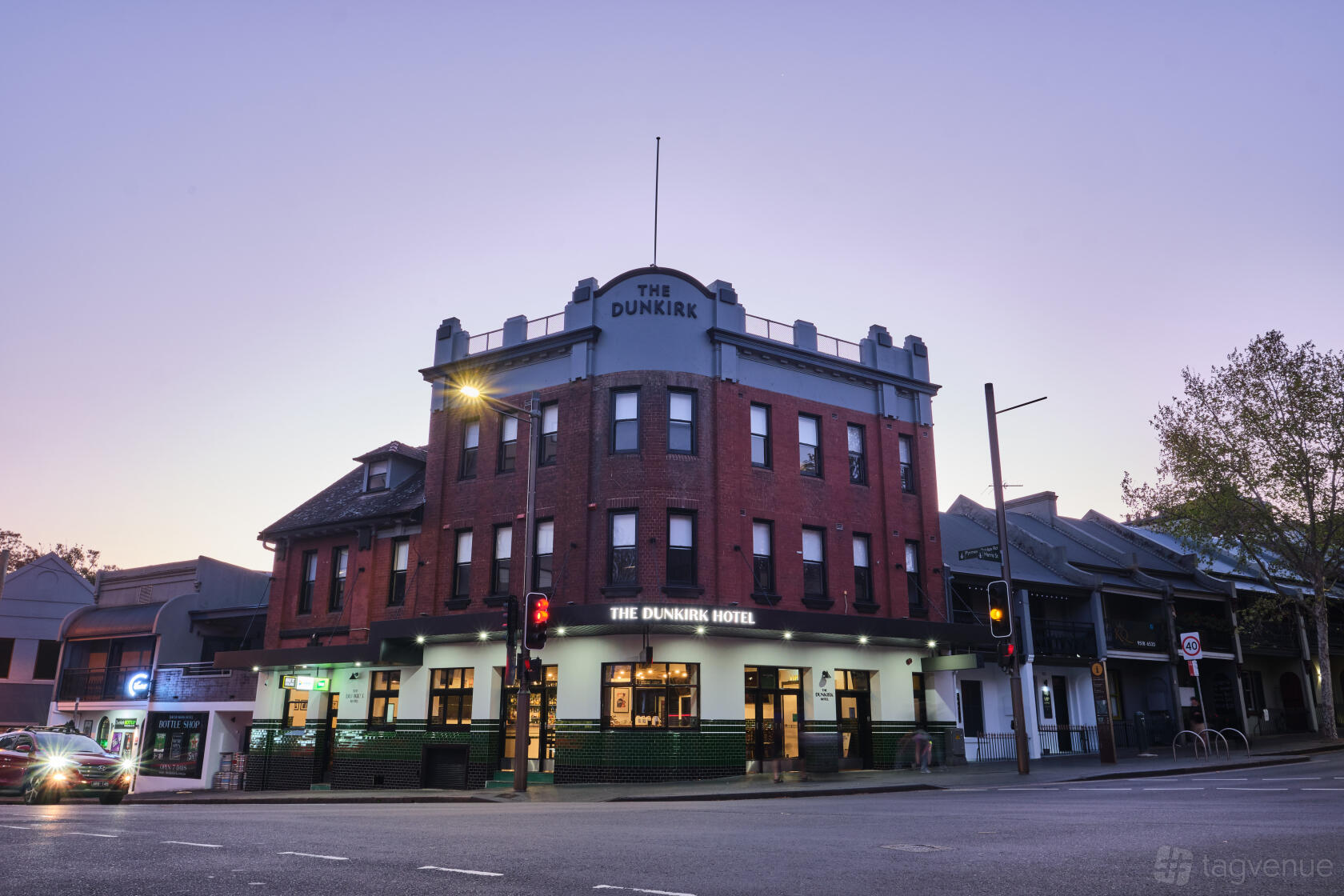 A red brick hotel with arched windows and green accents at Dunkirk Hotel.
