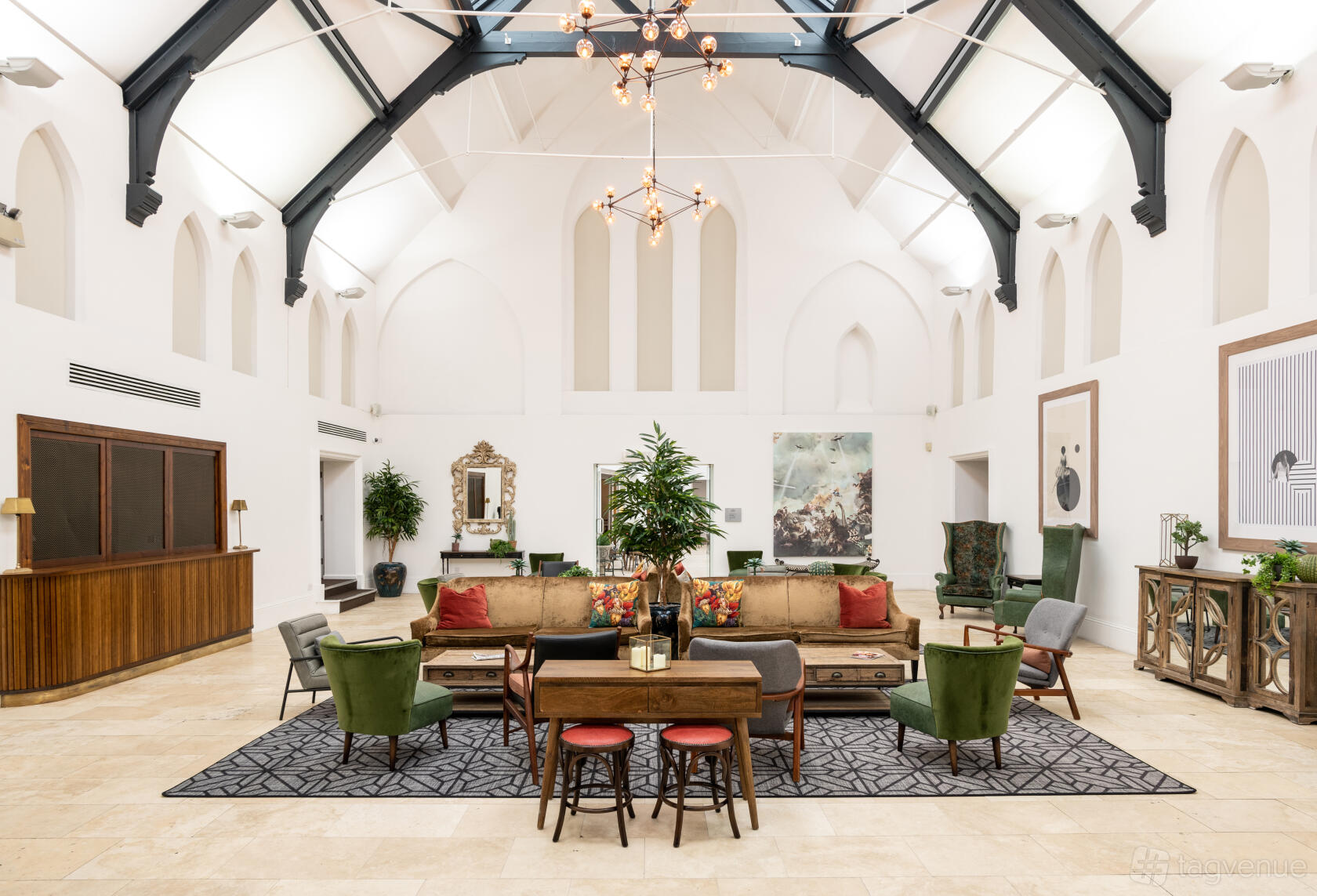 An event venue with high vaulted ceilings, arched windows, and eclectic lounge seating at Fazeley Studios.