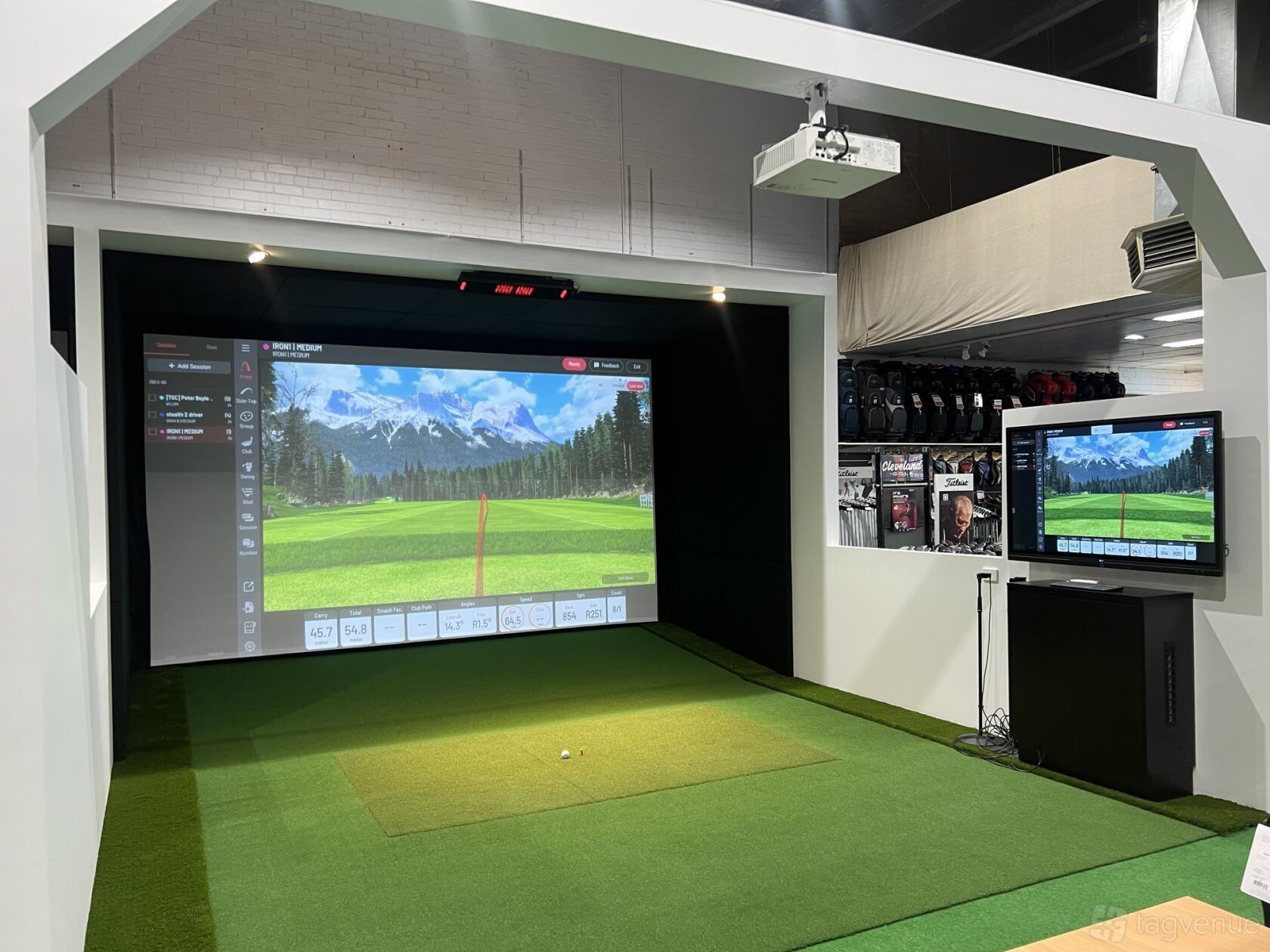 An event venue with an indoor golf simulator, artificial turf, and a digital scoreboard at GolfSim Braeside.