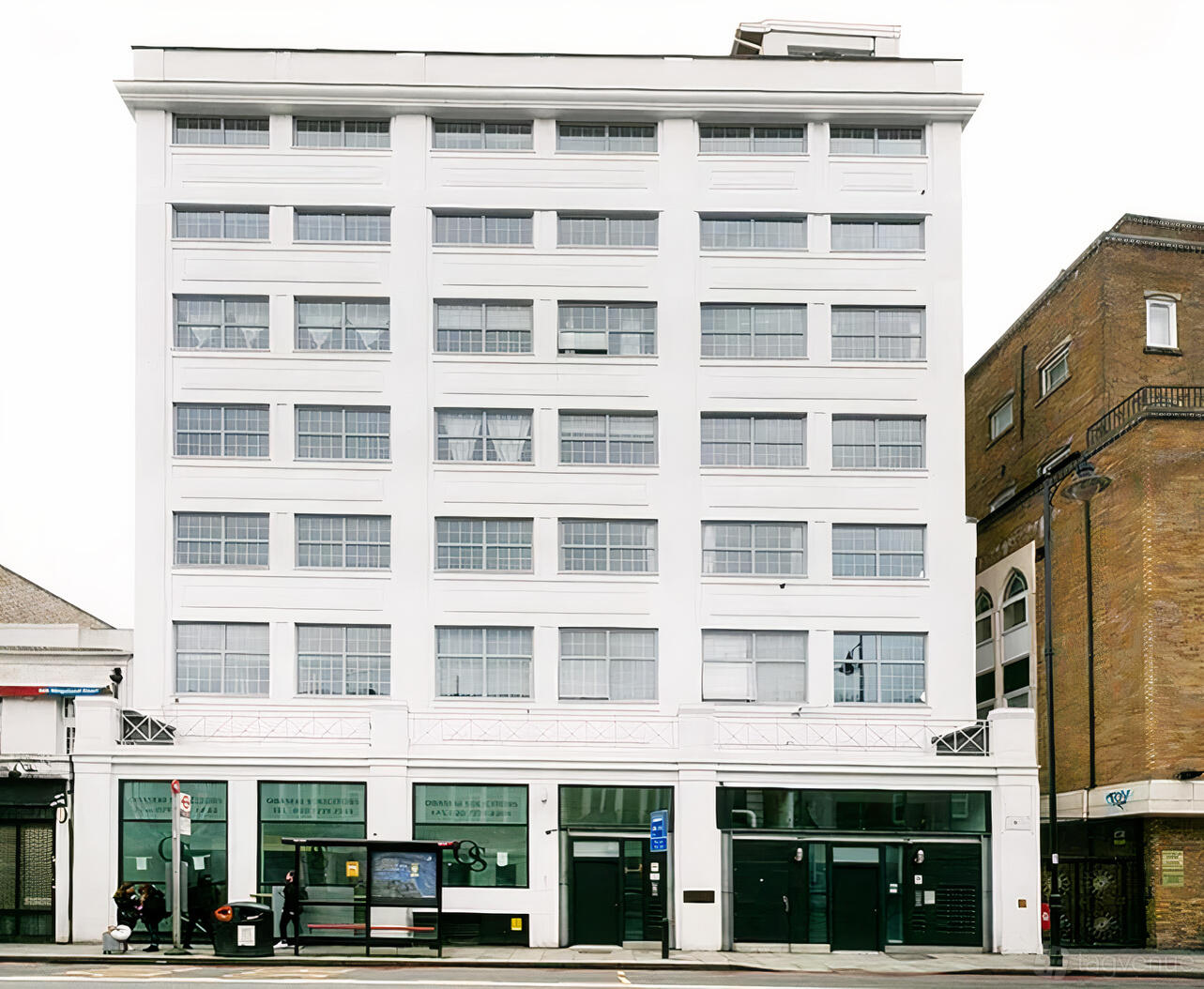 A white multi-story building with large grid windows at House of Transformation - Event Space.