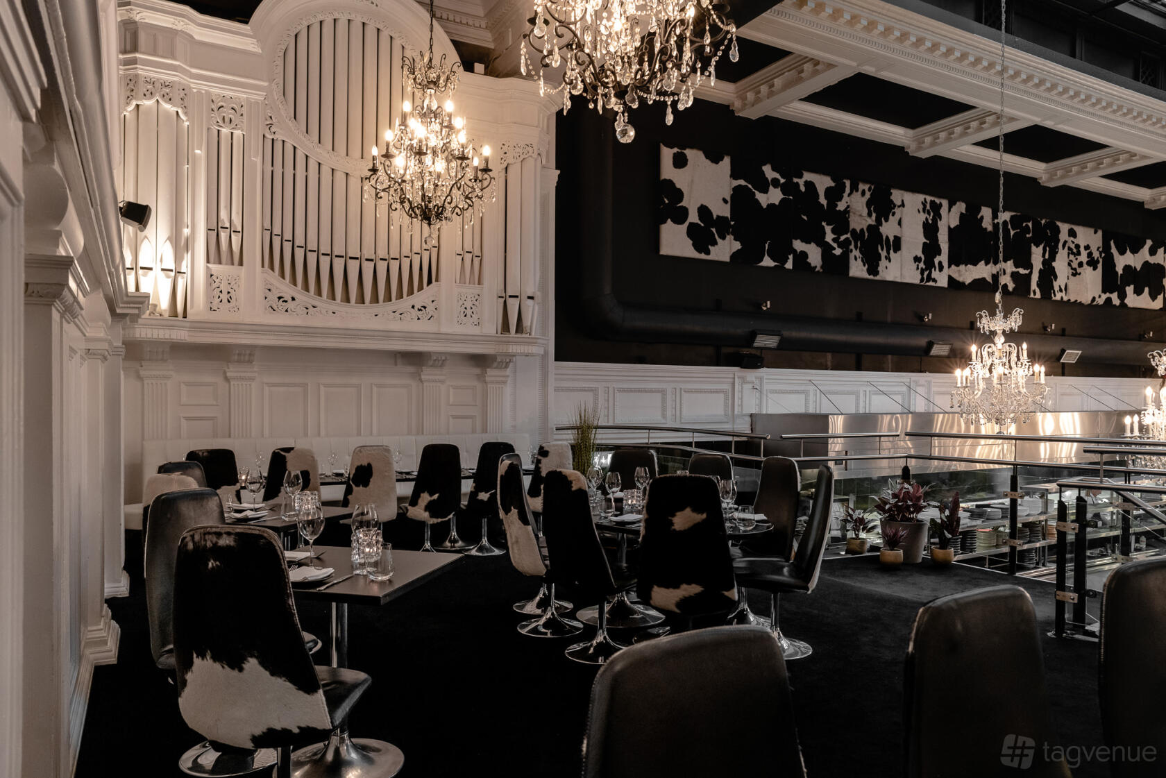 An event space with chandeliers, cowhide chairs, and a white pipe organ at Gaucho Manchester.