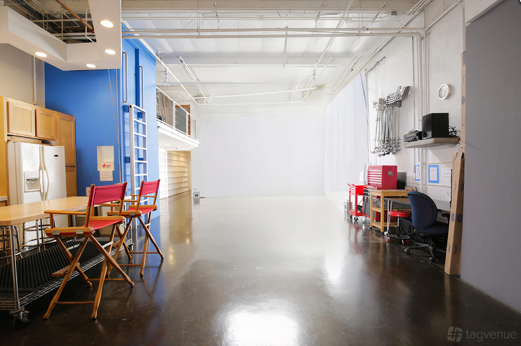 An event studio with polished concrete floors, white walls, and a kitchenette at MagicLight Productions.