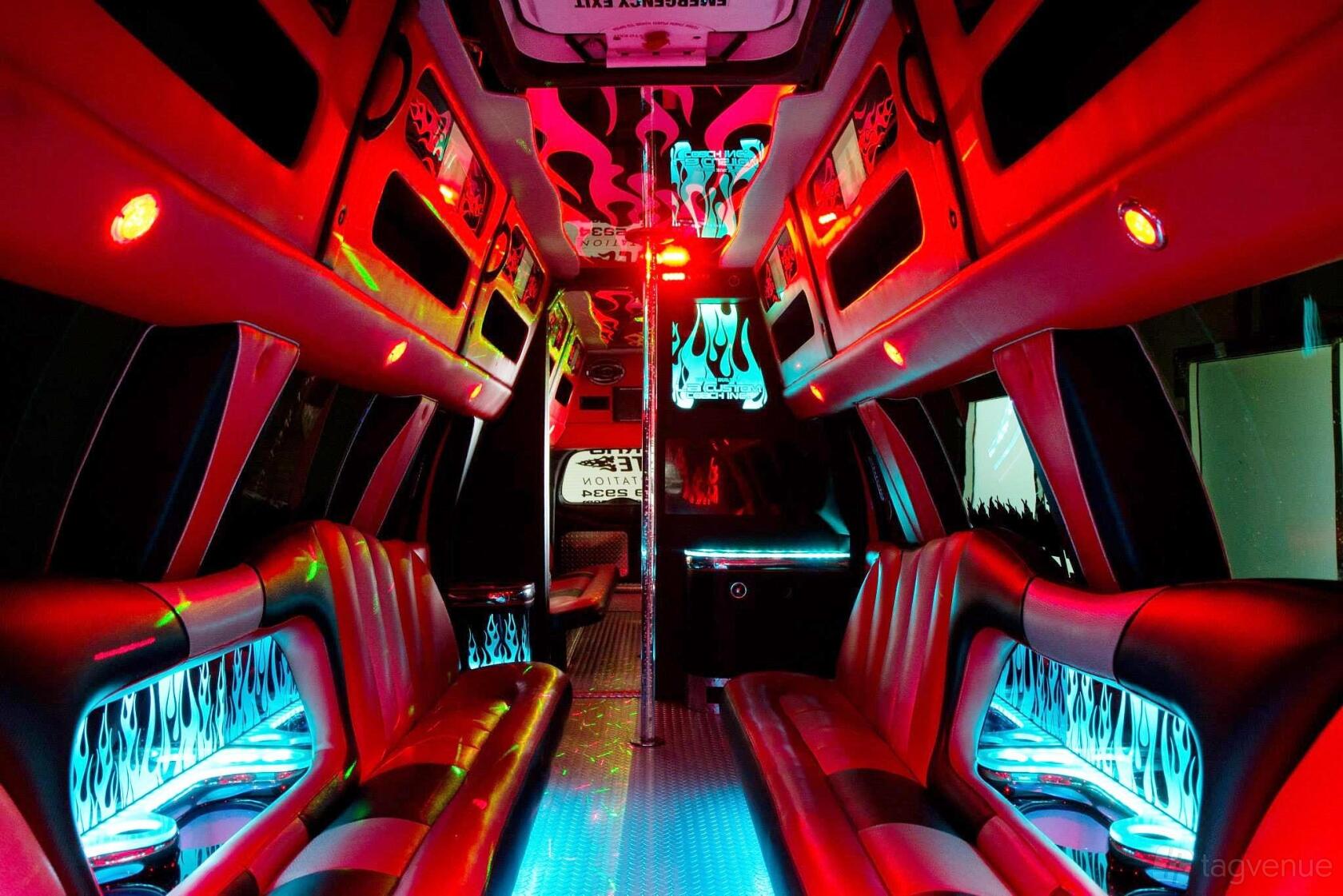 A party bus with neon lighting, leather bench seating, and glowing flame graphics at Nocturnal Tours.