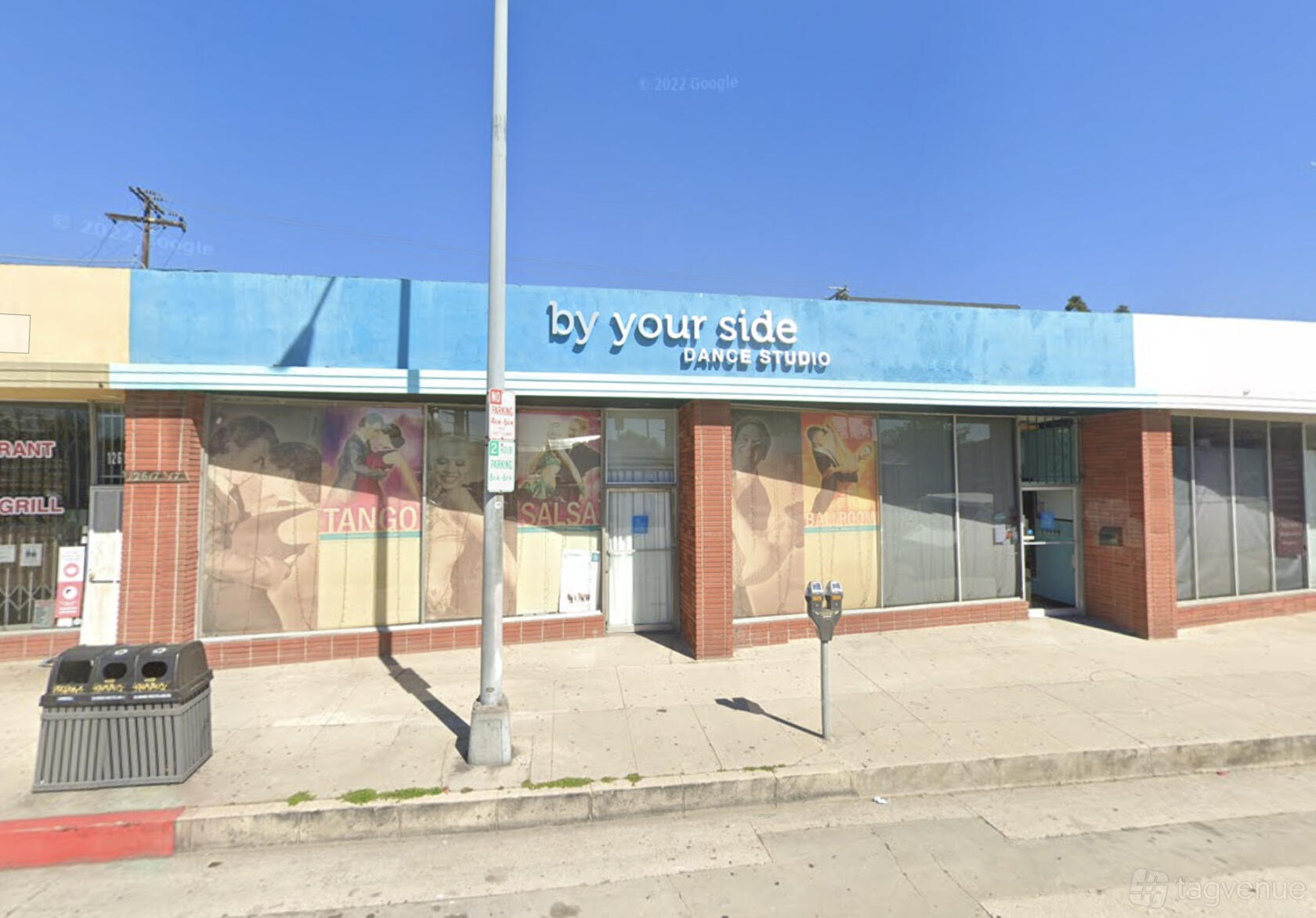 A storefront with large windows, colorful dance murals, and a blue sign for By Your Side Dance Studio Culver City.