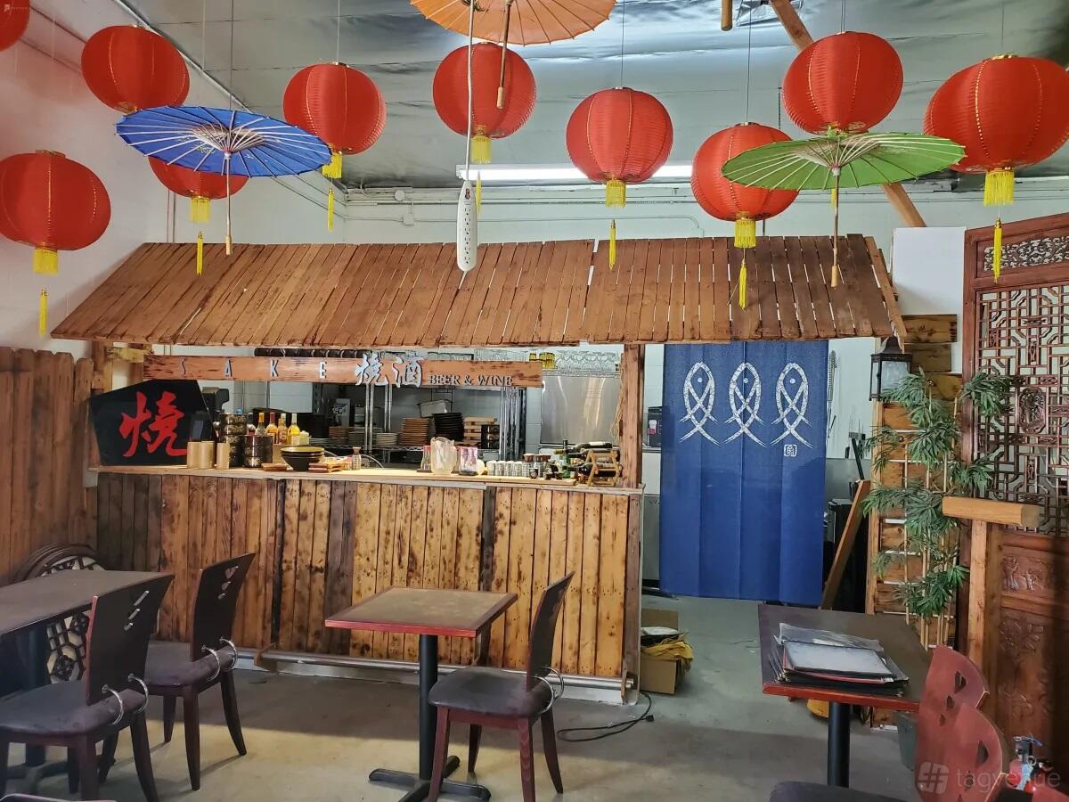 A photo studio with a Japanese-themed restaurant set, red lanterns, and bamboo counter at Cosmic Cube Creative Studio.