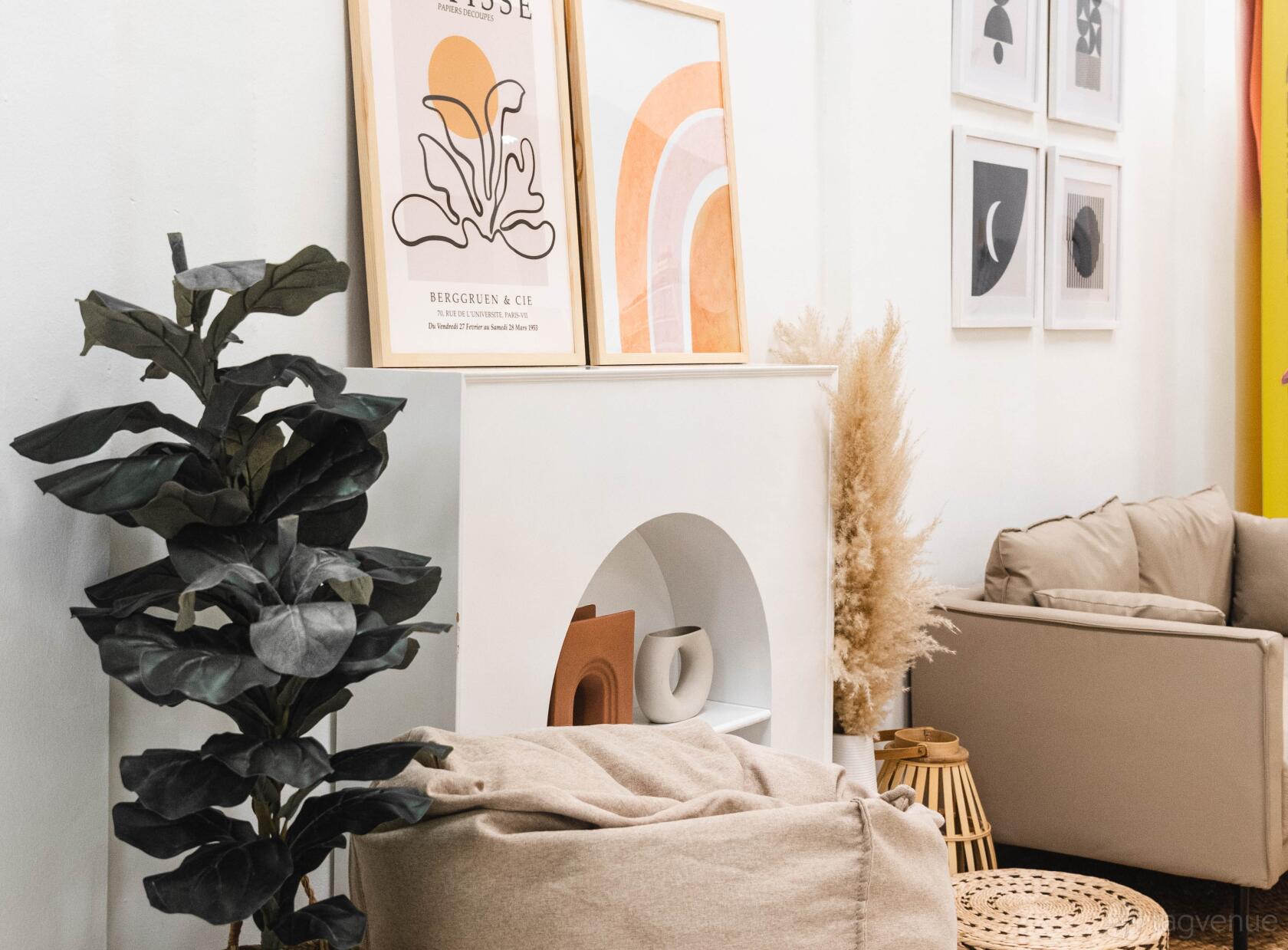 A coworking space with abstract wall art, neutral-toned seating, and indoor plants at Creative For More.