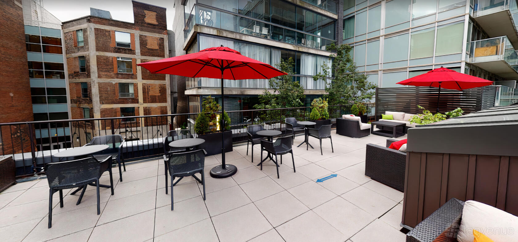 A terrace with red umbrellas, black patio tables, and potted greenery at IQ Offices - The Portland Patio.